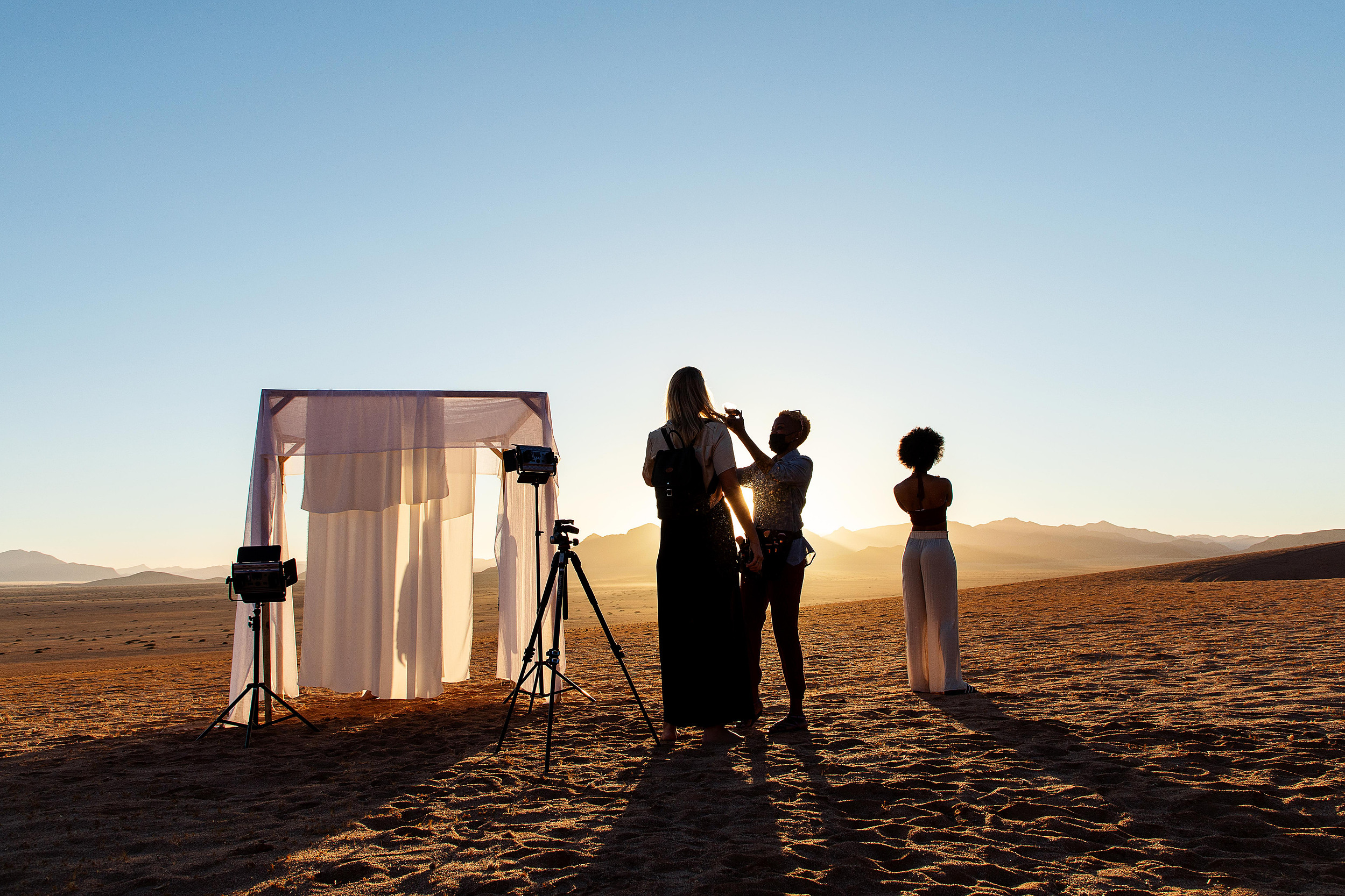 Behind the scenes — crew setting up at golden hour, Namib